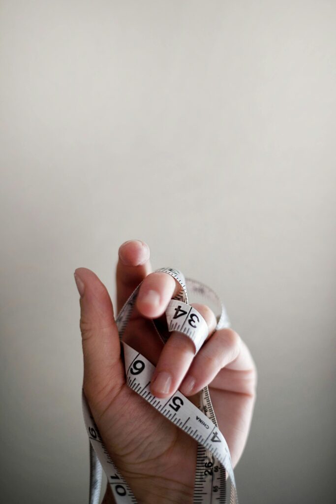 a hand holding a measuring tape