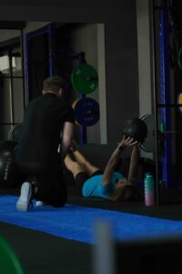 a woman lying on the floor with a man in the background